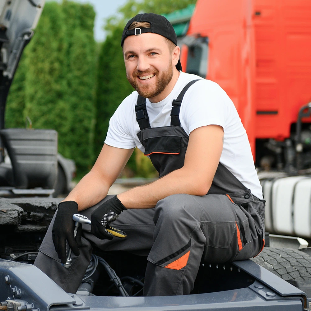 student smiling while working on truck